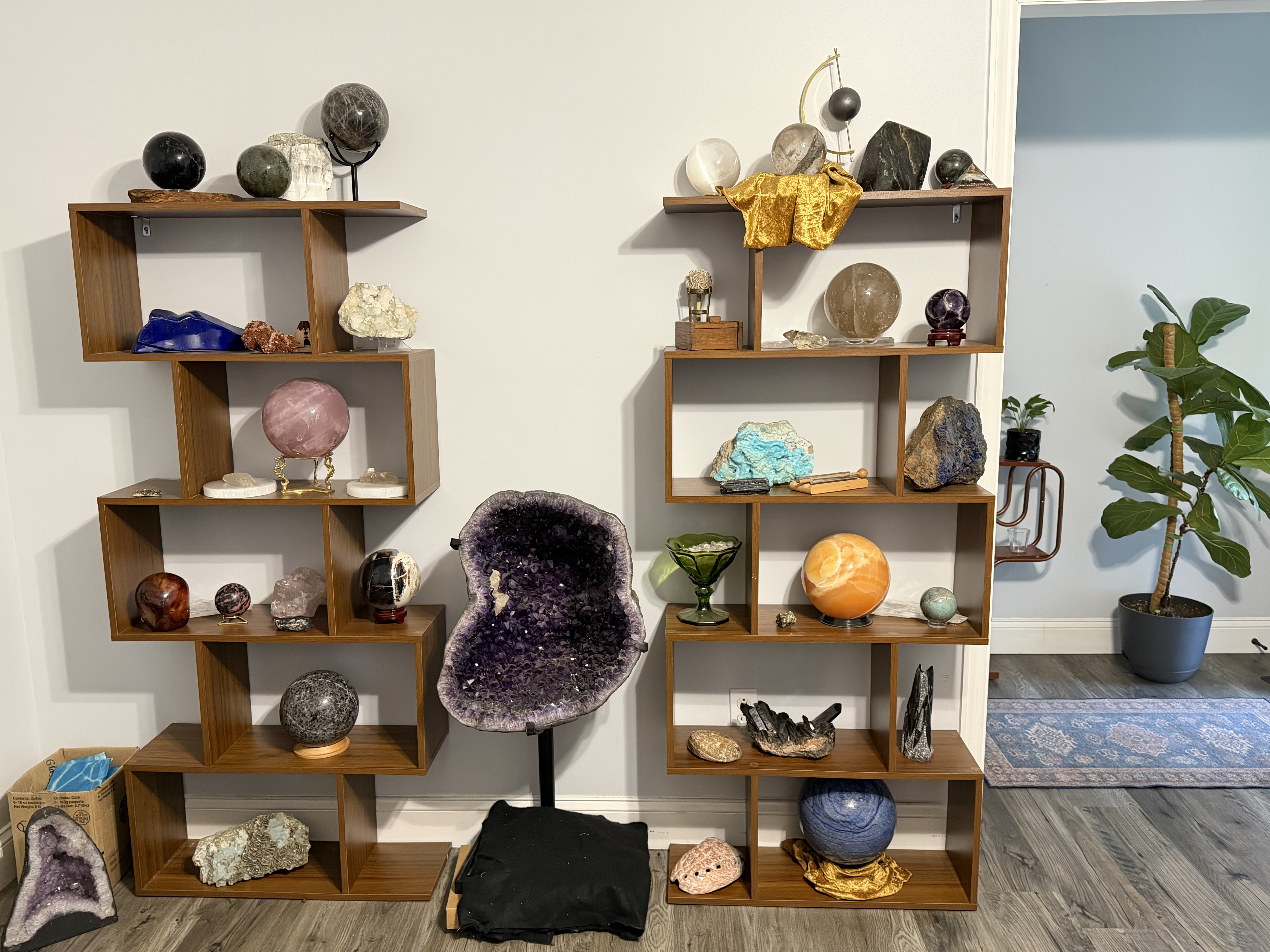 The rotating shelves — geodes, amethyst, spheres and raw stone that cycle through the practice